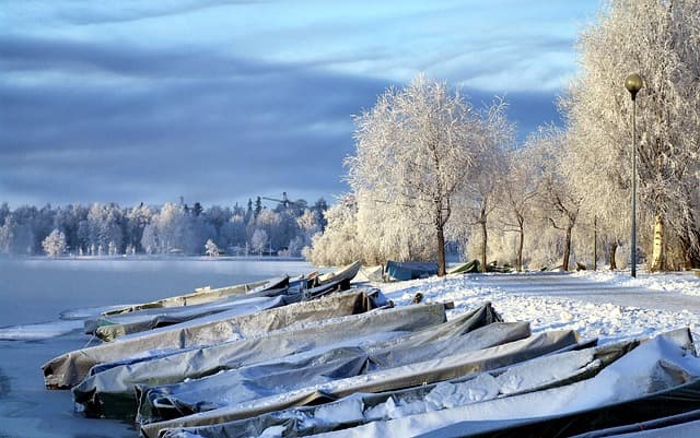 Boats on the banks of an icy river in Finland